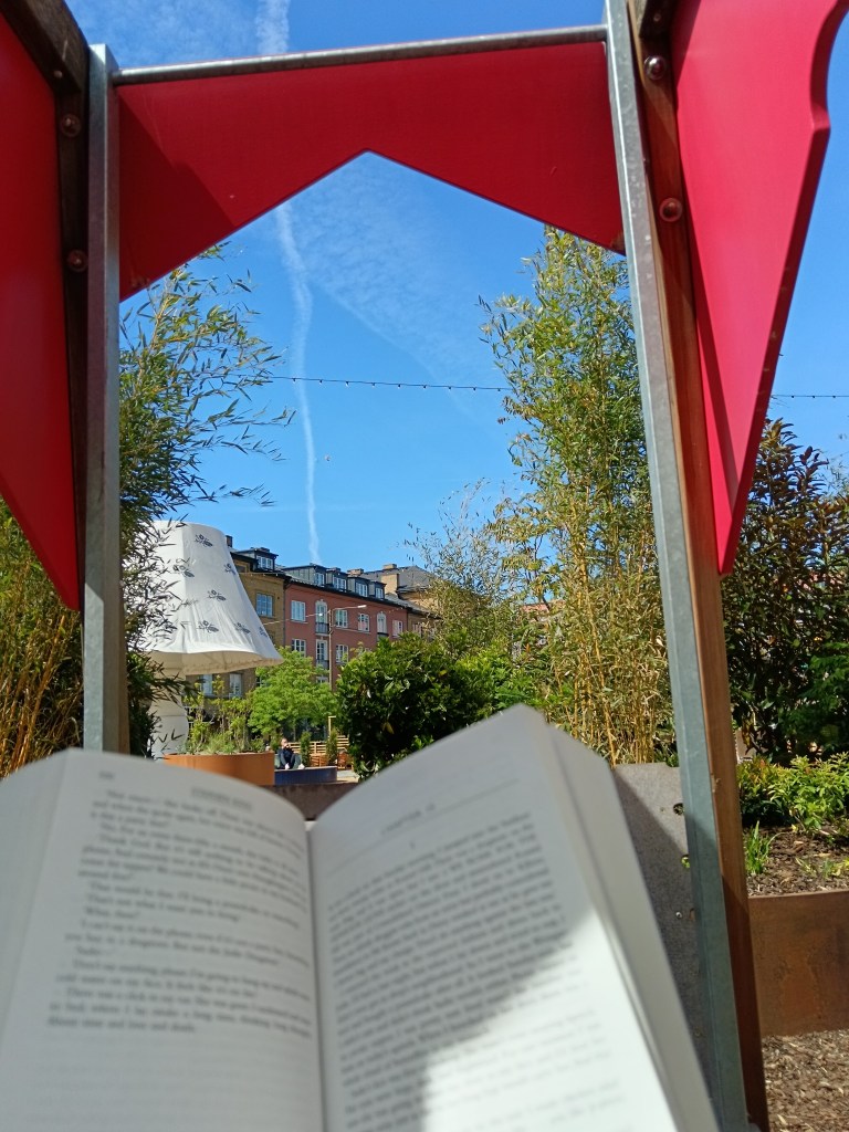 I hold my book in a park