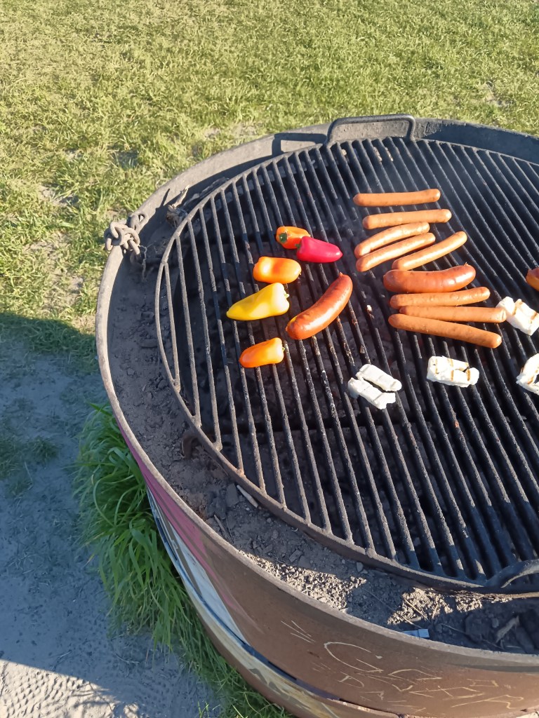 Sausages and peppers on a barbecue
