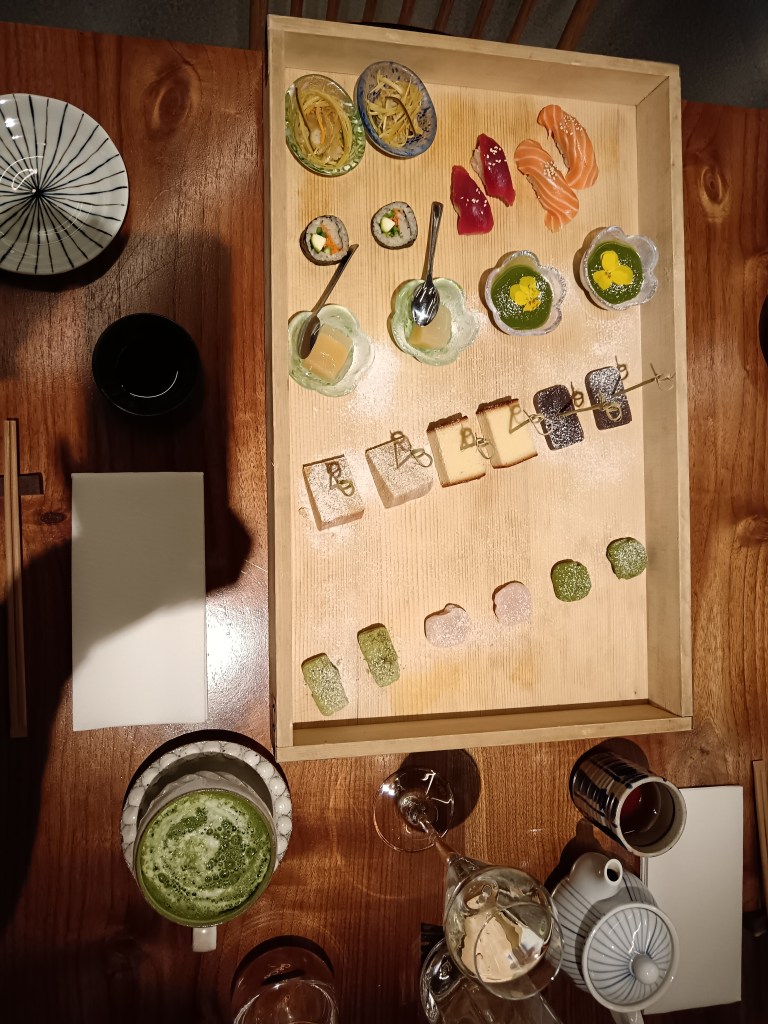 A tray of sushi and japanese cakes