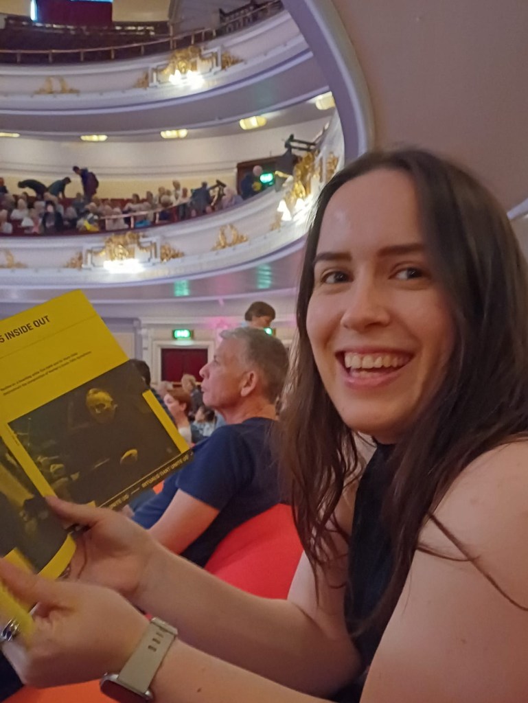 I smile and hold a show programme