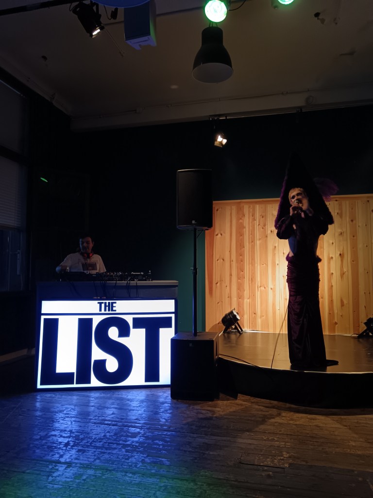 A drag queen sings on stage