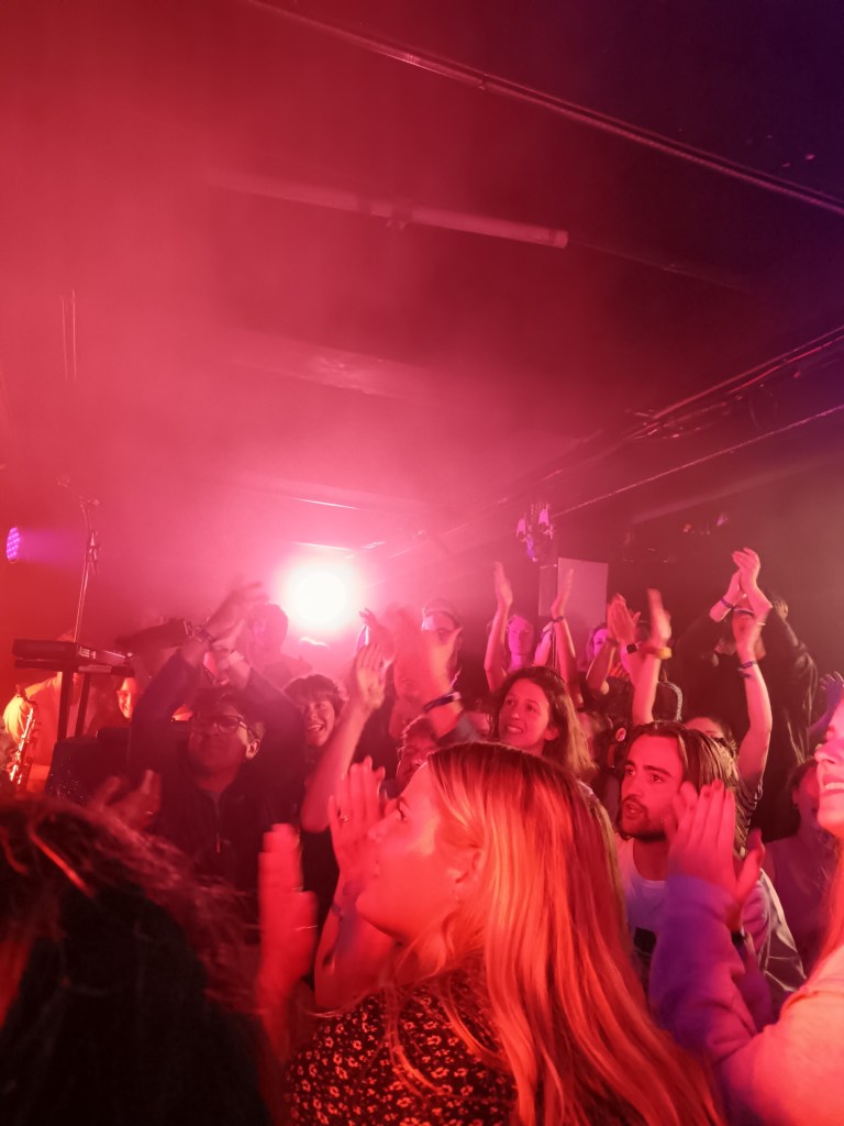 A crowded room of people clapping