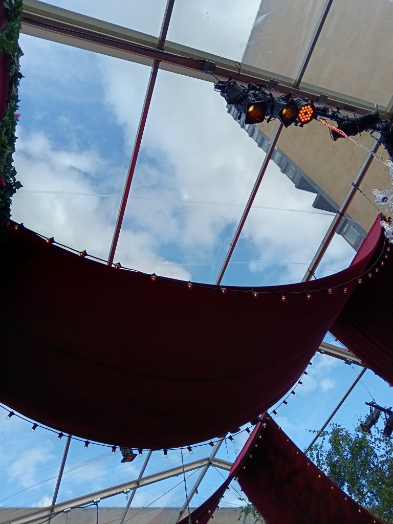 A red drape hangs in a blue sky