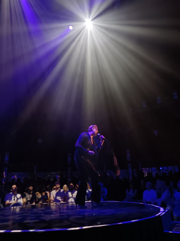 Reuben belts into a mic in an epic white light