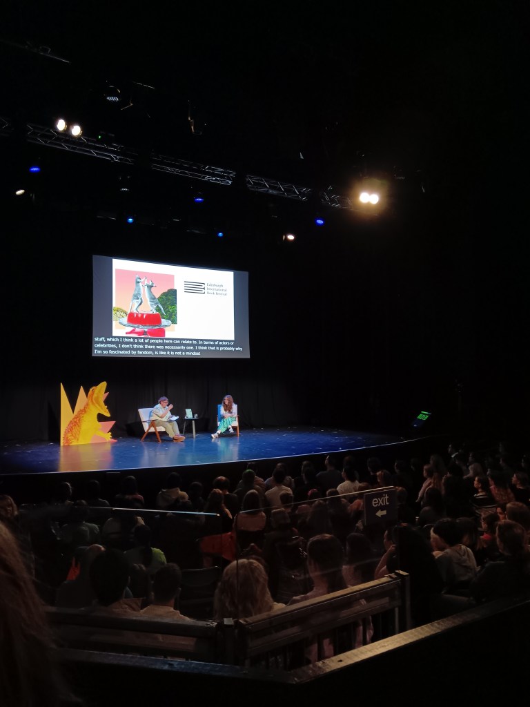 Alice and her interviewer on a stage
