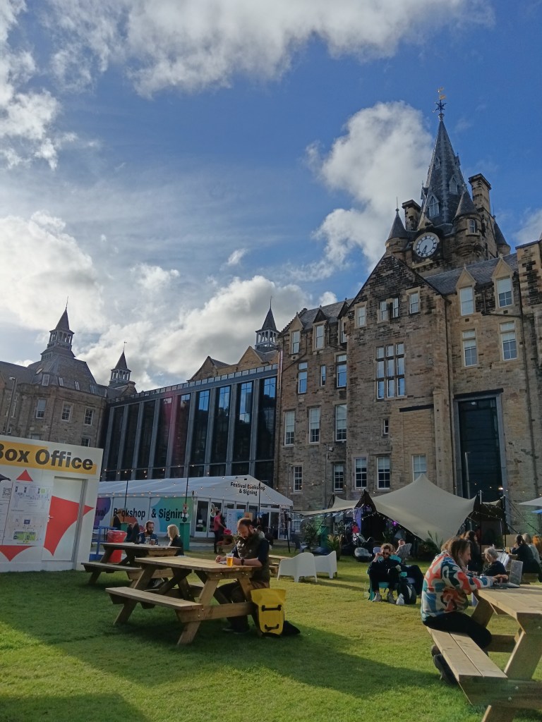 Picnic tables on grass in front of a grand old building