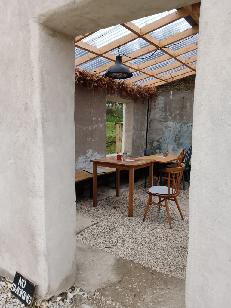 a ruined stone building with a plastic roof and dried flowers