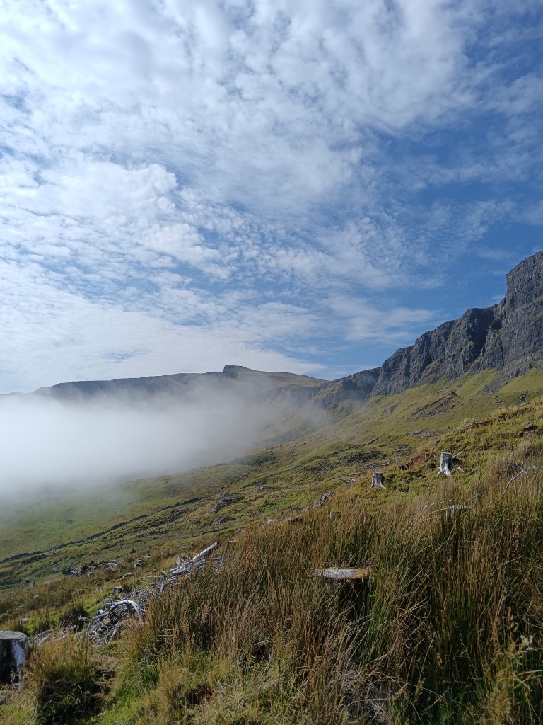 A hill and rocks half in fog