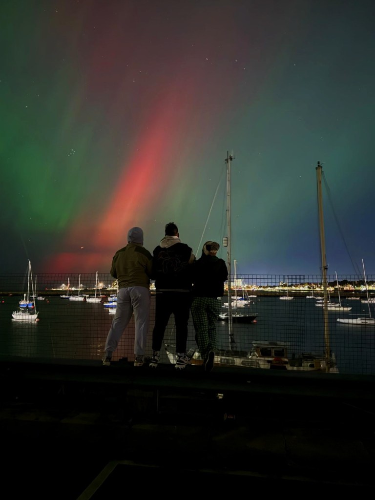 My friends and I stand looking out at the northern lights