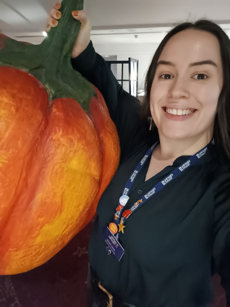 I hold up a giant prop pumpkin