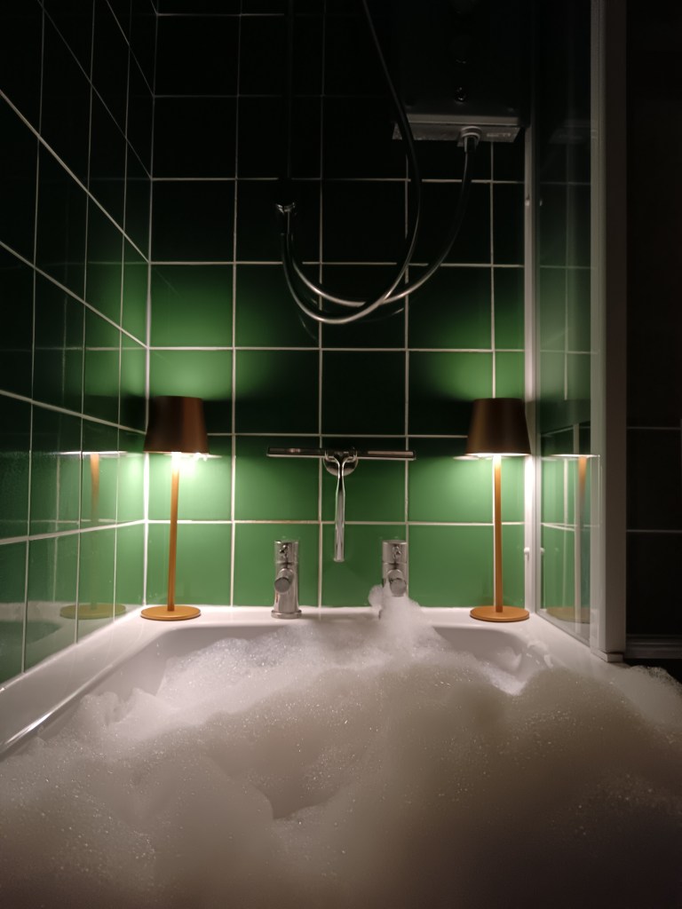 My bubble bath dimly lit by two gold wireless lamps