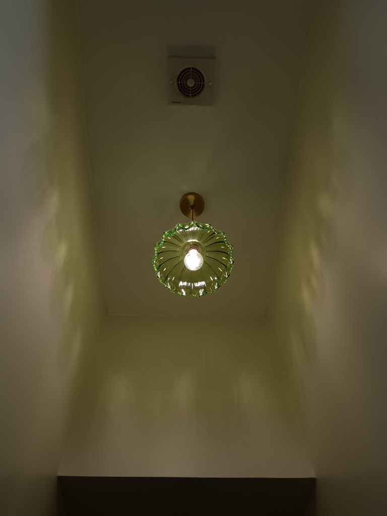 My green glass pendant light shines patterns on the wall