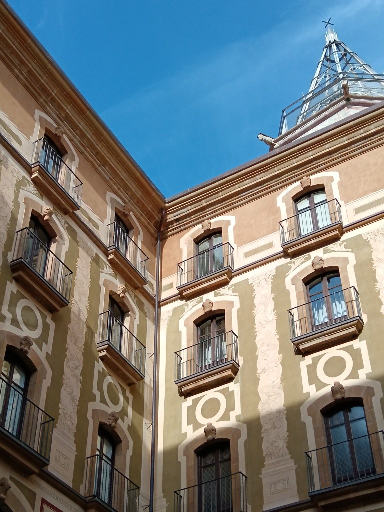 The sun hits the corner of a green painted building