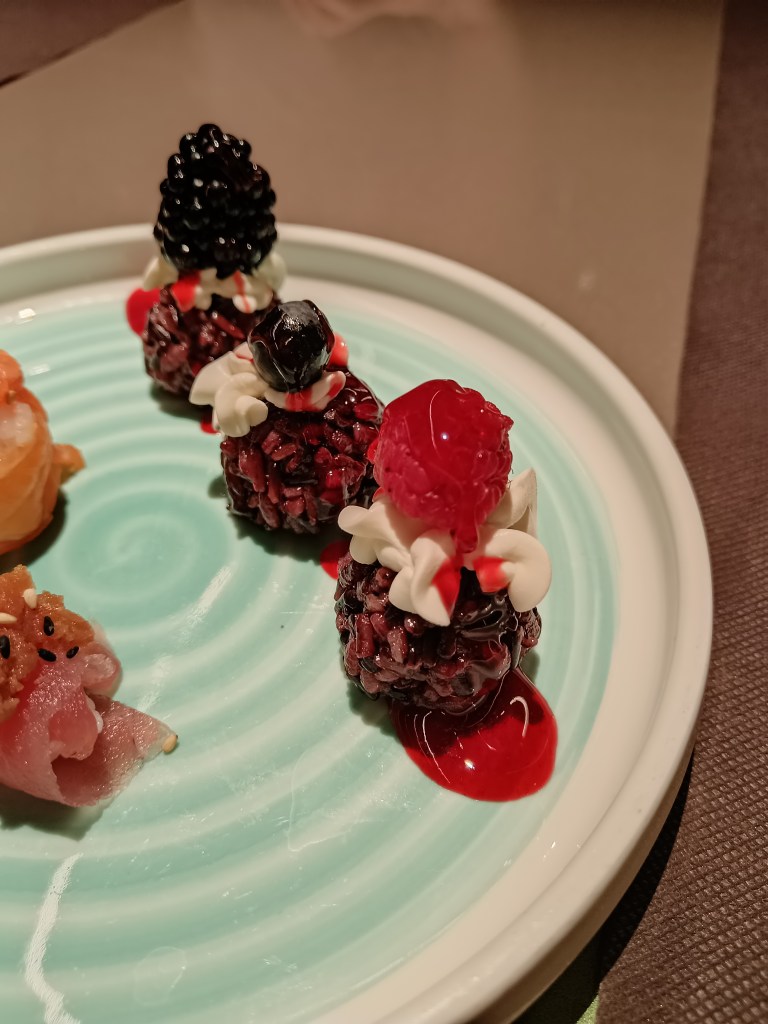 Sushi with berries sitting on top of it