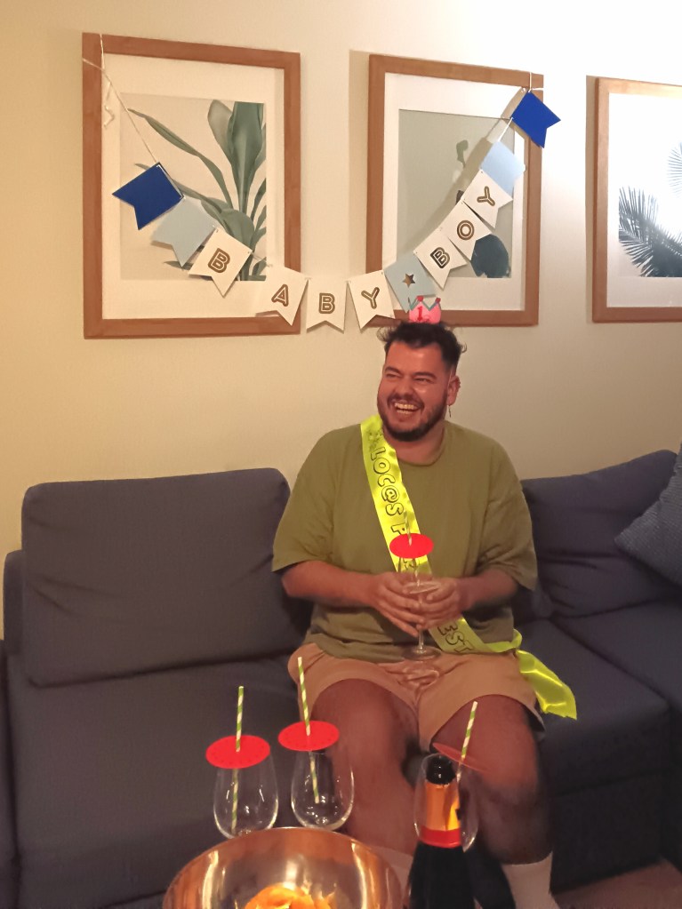 Bruno laughs wearing his little birthday corwn and a sash