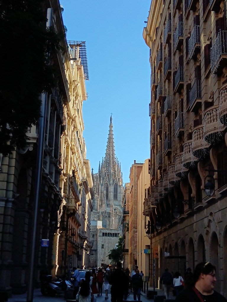 The cathedral pokes out between a balconied street