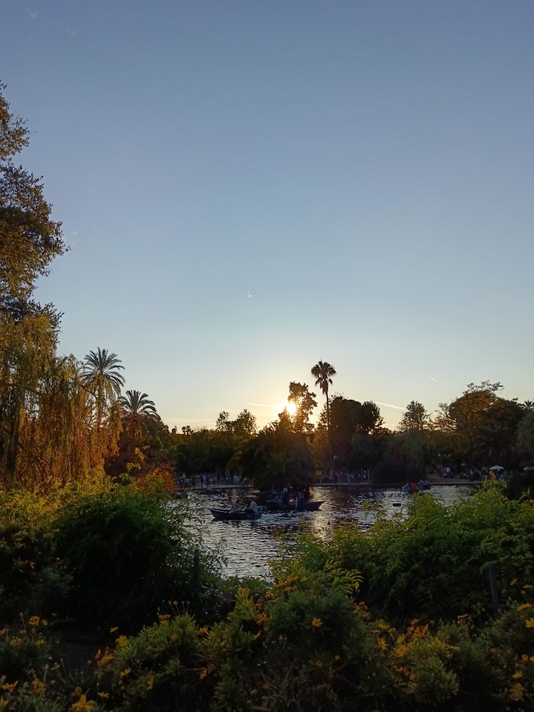 Boats float on the lake as the sun sets