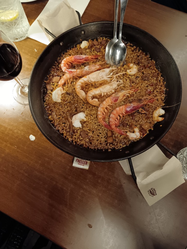 A paella dish with prawns on top