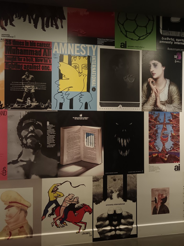 A wall covered in Amnesty International posters