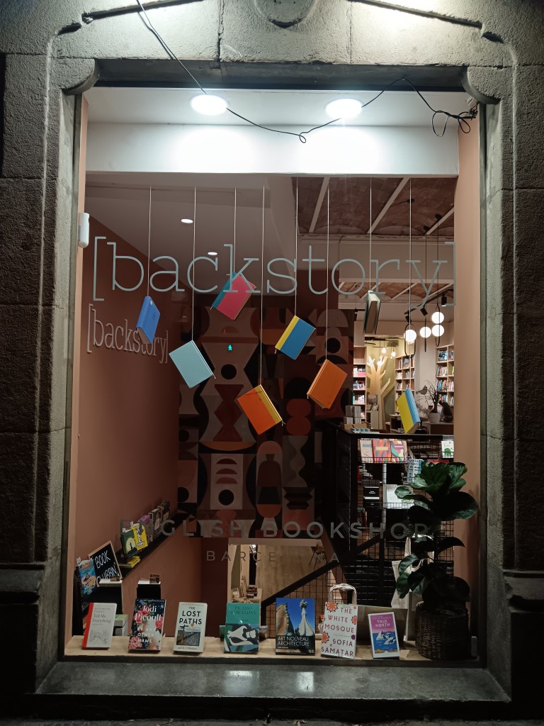 Books hang from string in the window of a bookshop
