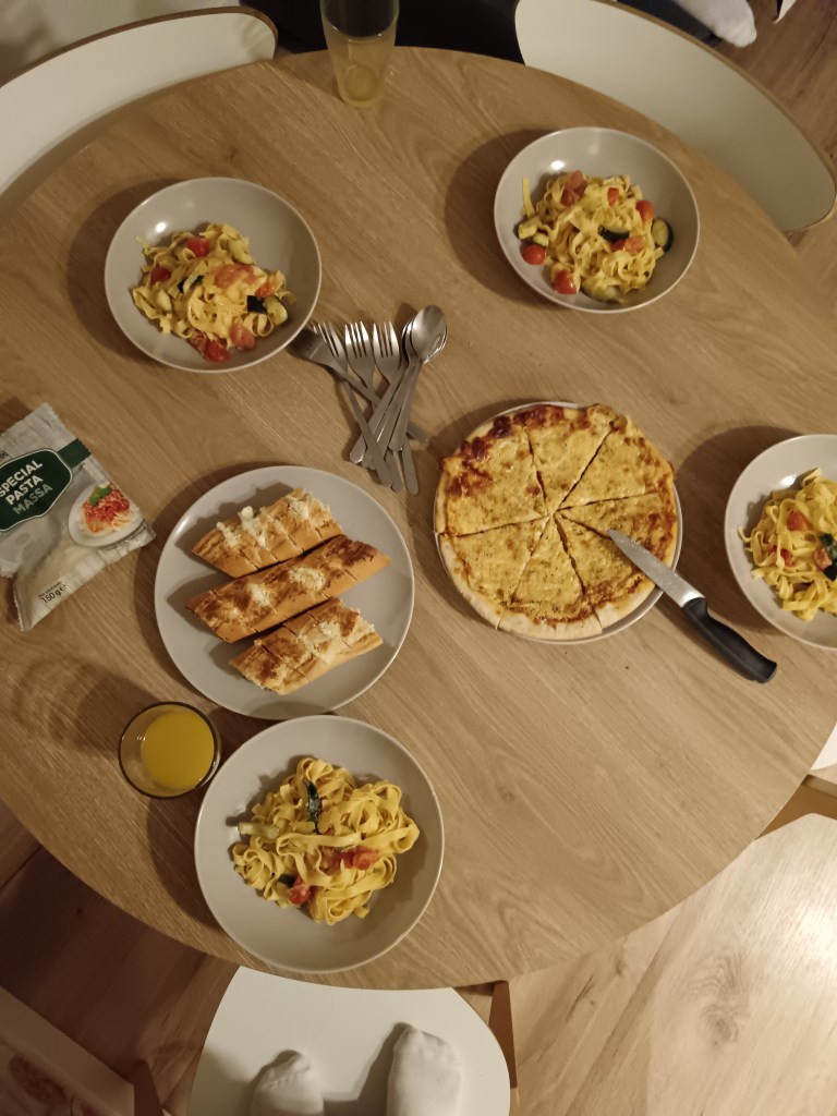 A table with pasta dishes and garlic bread