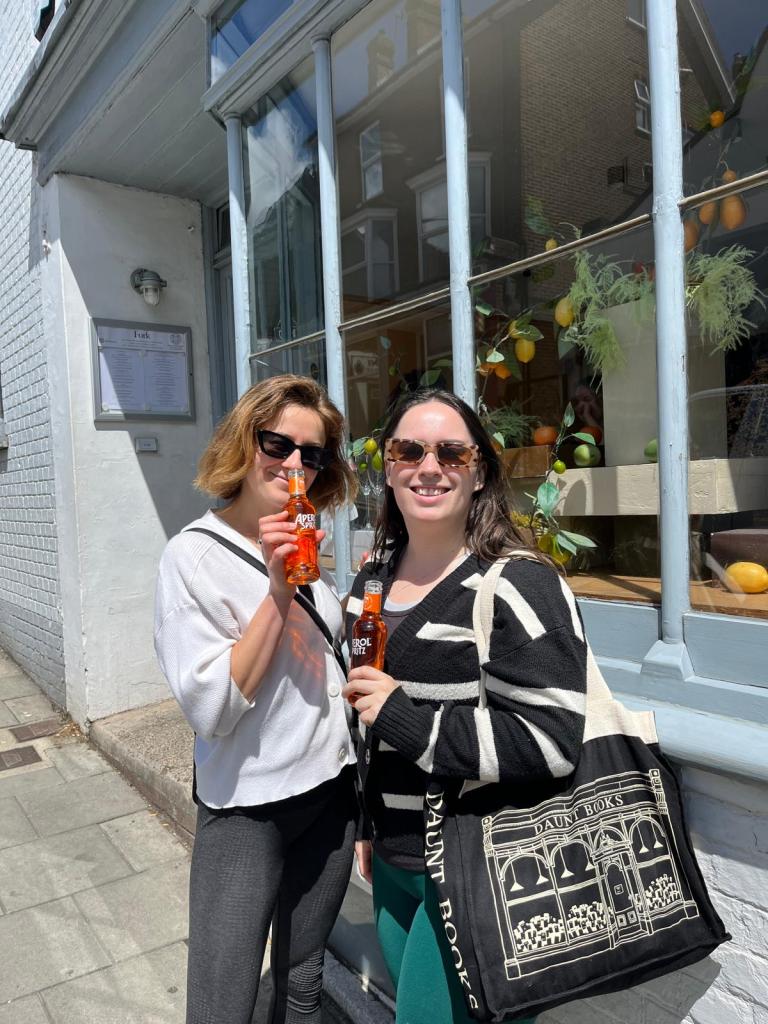 Marion and I smile with mini aperol bottles