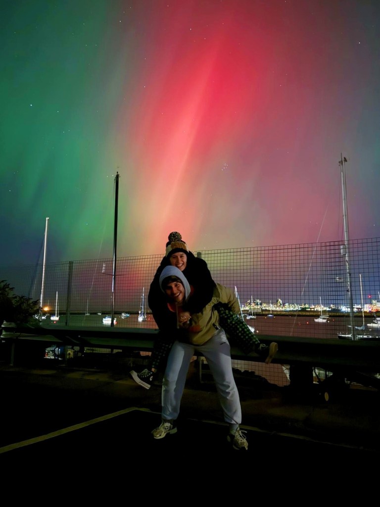 Ethan gives me piggy back in front of aurora borealis