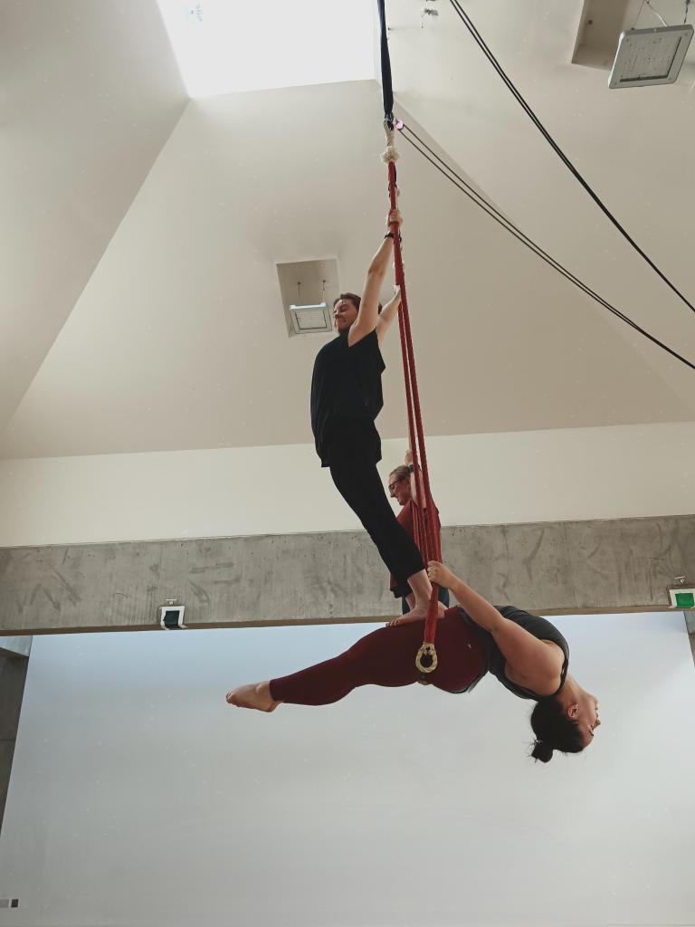 Pairs trapeze ejay stands on my legs as I bend back