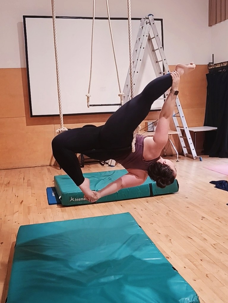 I bend one leg and hold the other straight lying on a trapeze