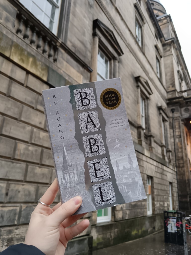 I hold Babel beside an old building