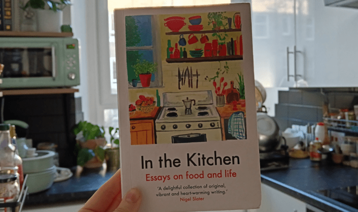 I hold up a book called 'In The Kitchen' in my kitchen