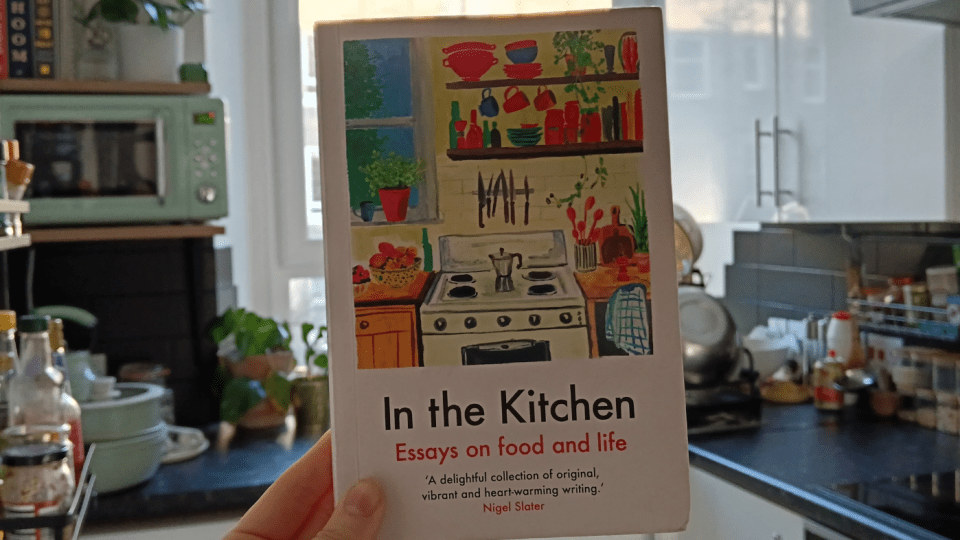 I hold up a book called 'In The Kitchen' in my kitchen