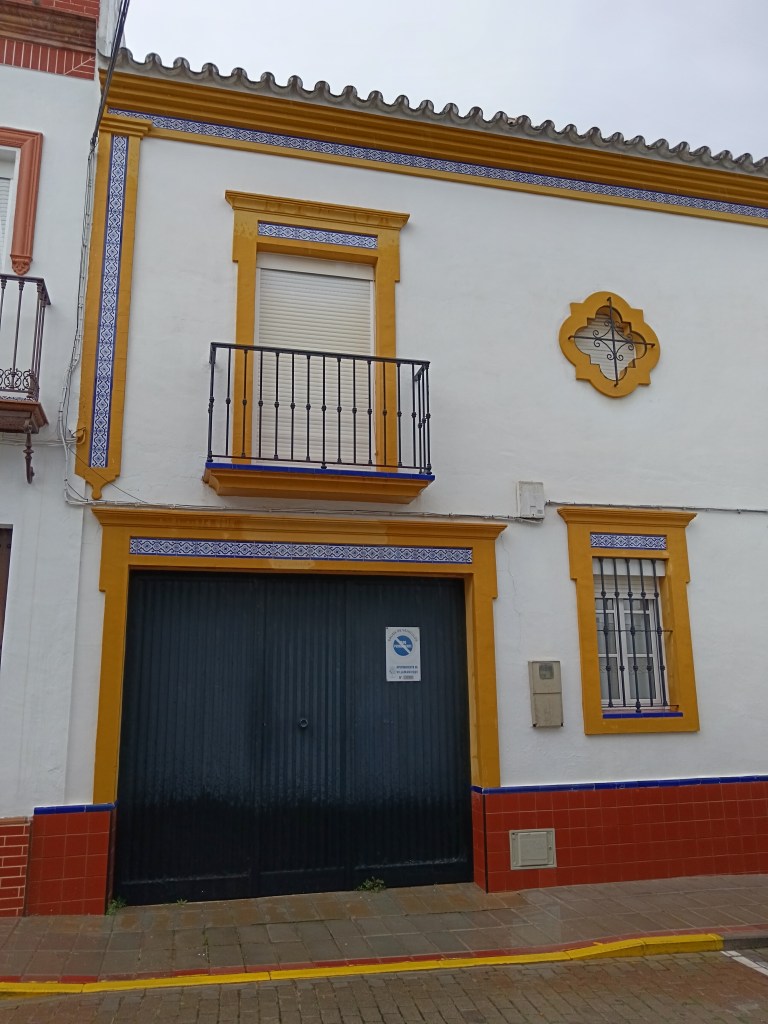 Cute house front with yellow painted detail and blue tiles