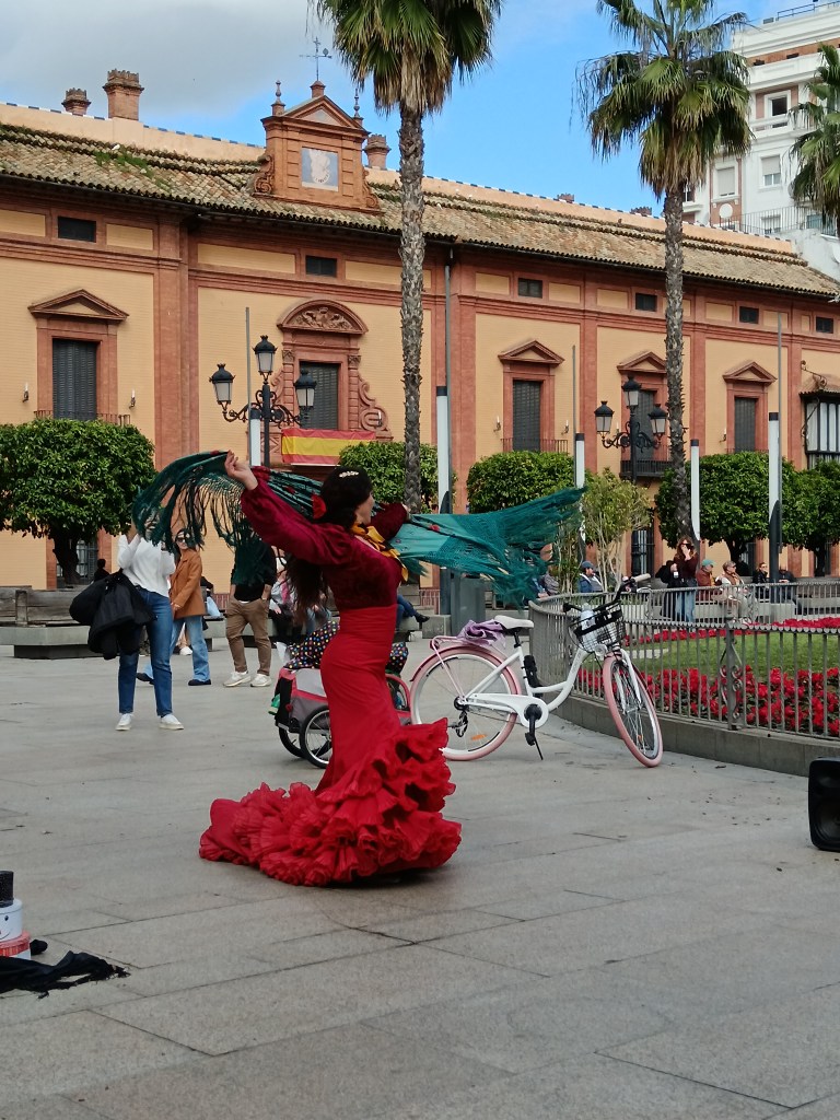 A flamenco dacner in the streets swings her fringed shawl around