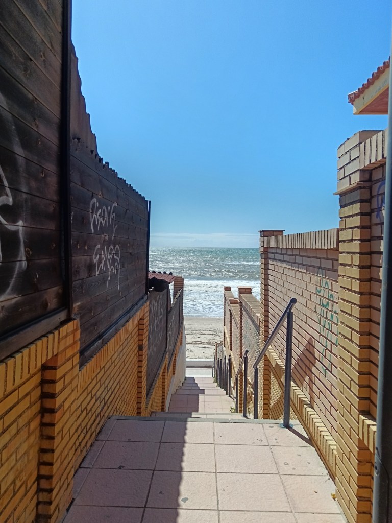 Through a pathway you can see the beach in the distance