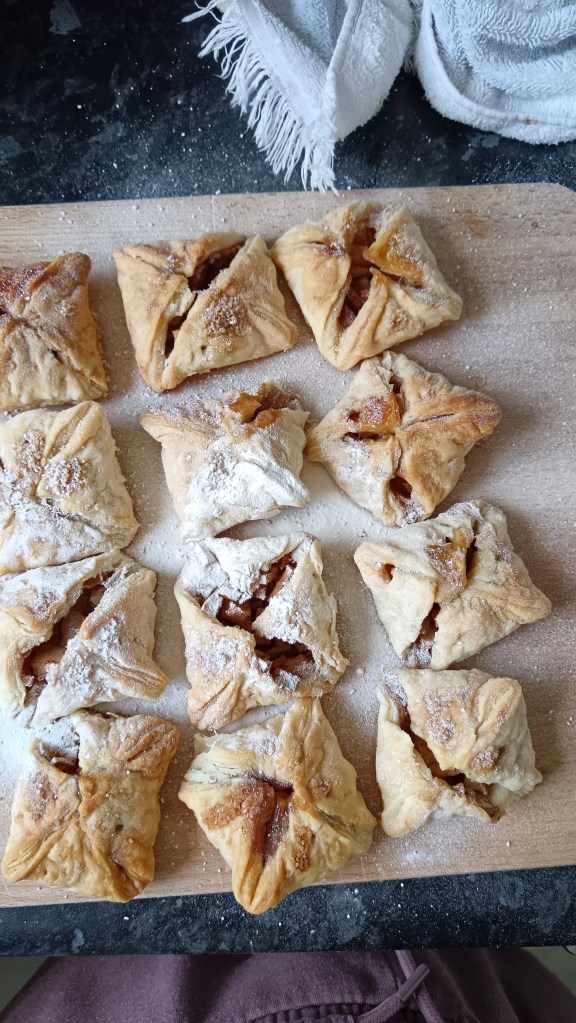 A chopping board covered in square apple pastries