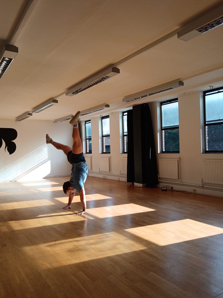 Ethan cartwheels in a sunny dance studio