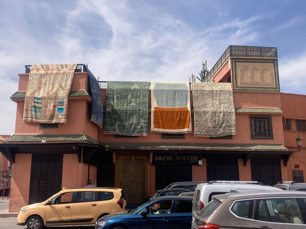 Rugs hangiing over the roof of a building