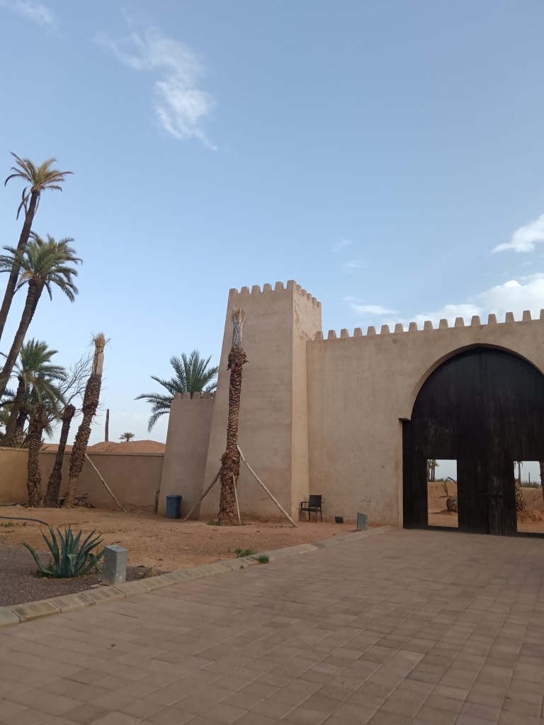 A large wall and door leading to the desert sand dunes