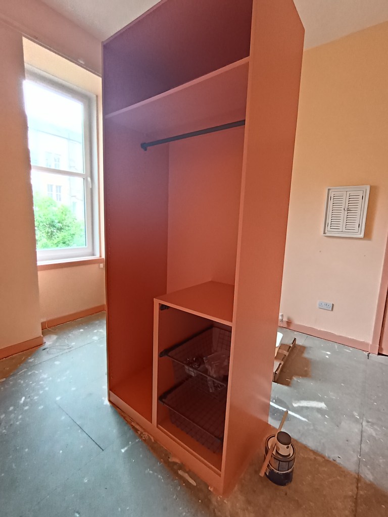 The inside of my wardrobe now painted a light terracotta colour