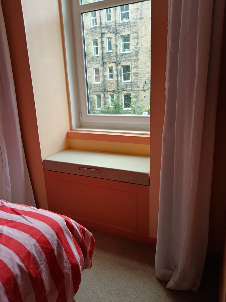 The finished window seat, that fills the gap between the window and the walls, with a fabric cushion on top