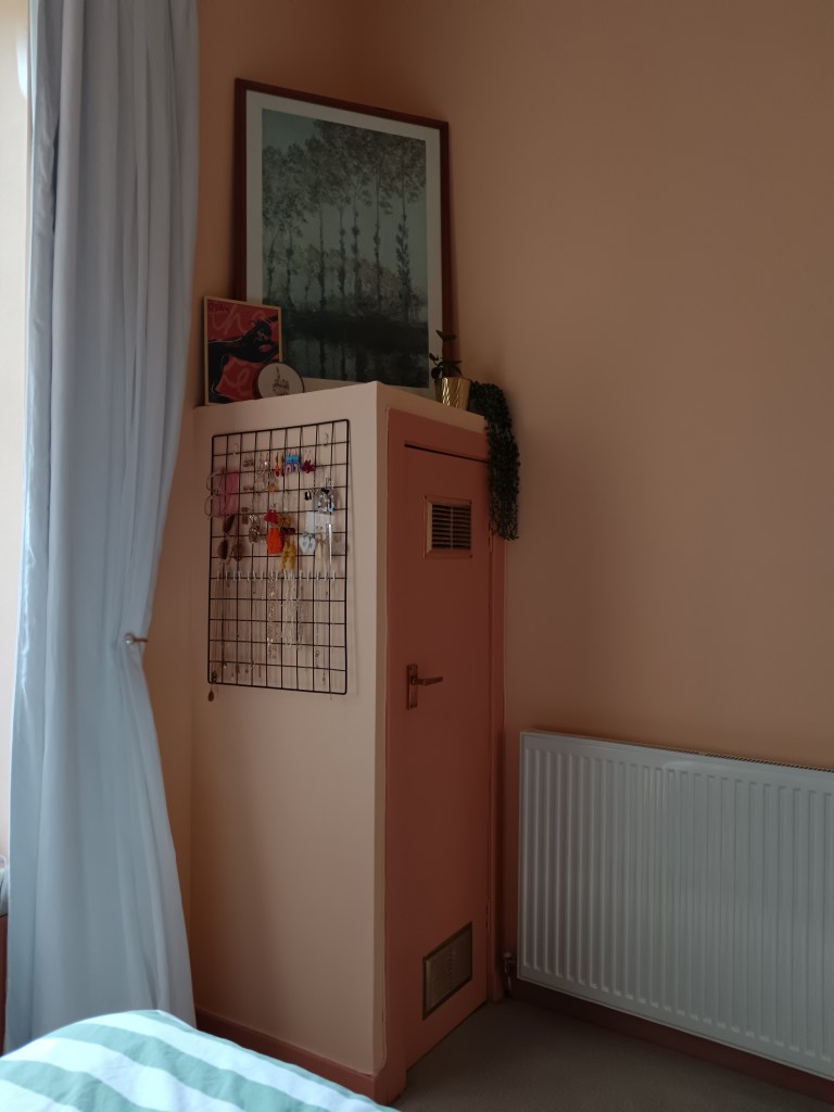 On top of a wee boiler cupboard I have a large frame with a print and drapey plants and other art layered in front