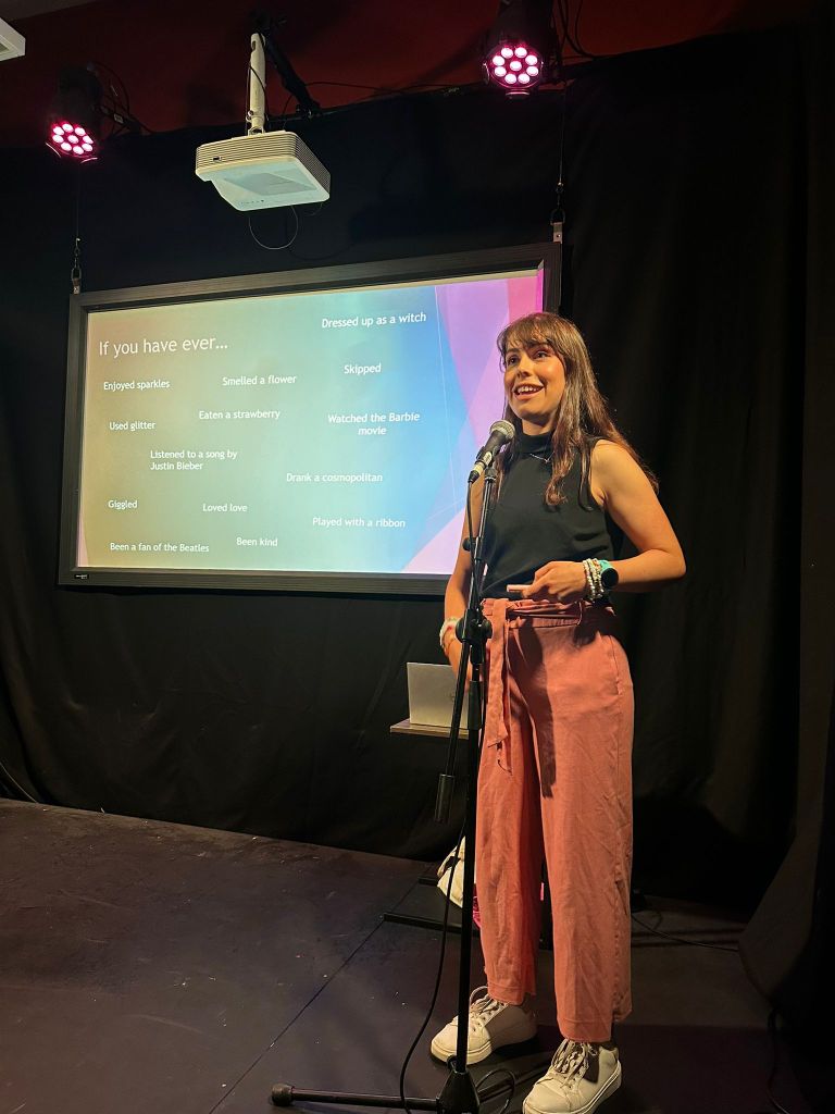 Sarah smiles in front of her presentation screen