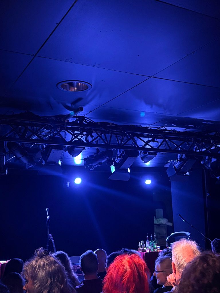 Blue lights shine on a crowded room