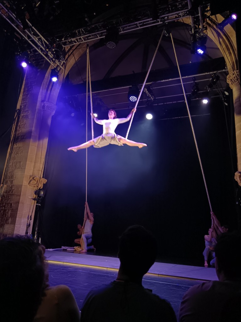 A girl is straddled held up in the air by a rope