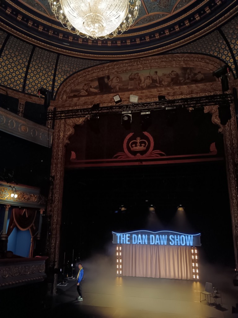 A grand theatre with a lighted arch on stage
