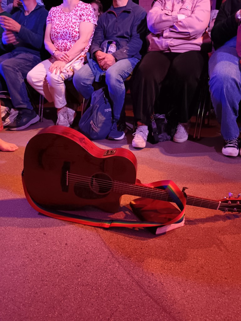 A guitar and a notebook on the ground