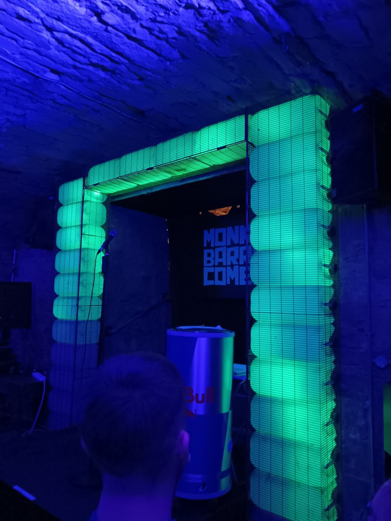 Green lights form an archway around a stage