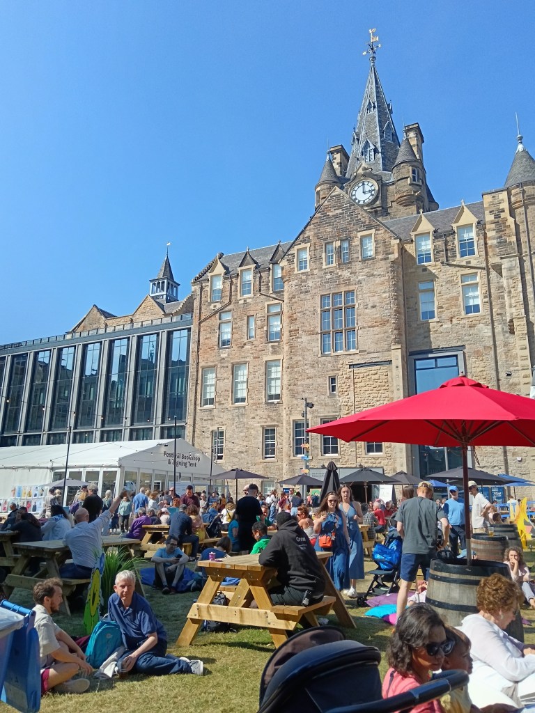 The busy book festival site with people sitting everywhere