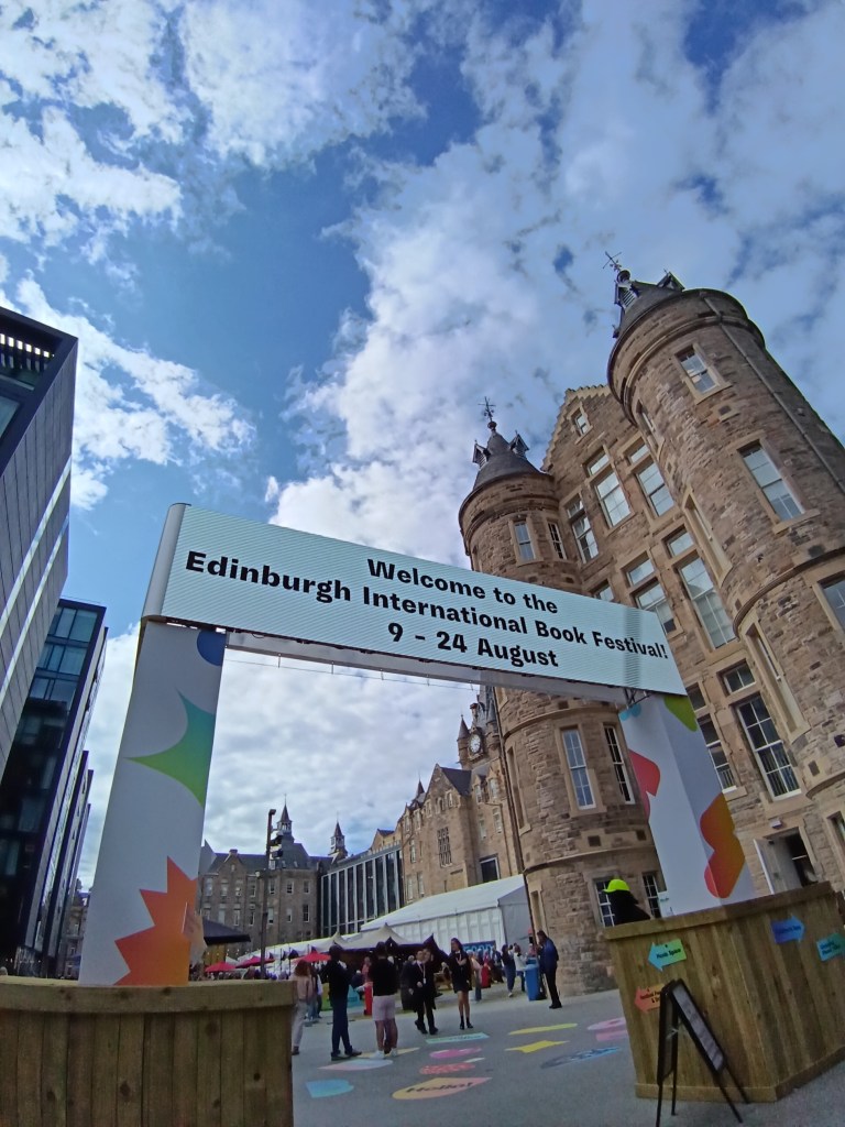 The entrance sign to the book festival against a grand building